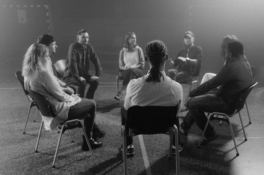 Mastering the First Impression: Your intriguing post title goes here A diverse group of people in a circle discussing and supporting each other in a therapy session.