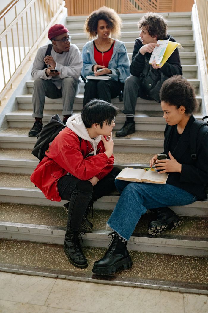 The Art of Drawing Readers In: Your attractive post title goes here A diverse group of students studying together on indoor stairs, promoting collaboration.